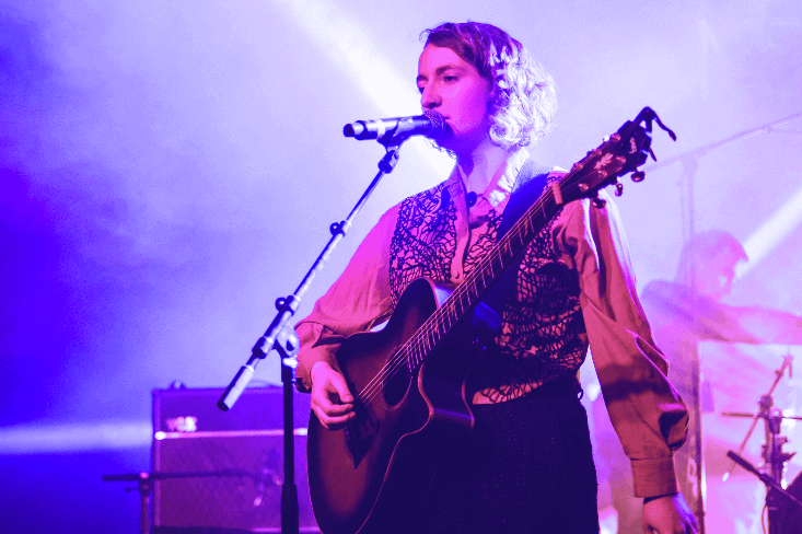 Woman singing and playing guitar on stage